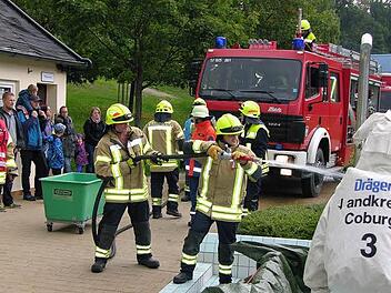 Stellvertretender Kommandant Norbert Wurst verfolgt, wie der Schutzanzug einer Einsatzkraft per Wasserstrahl gereinigt wird. Foto: Klaus Oelzner