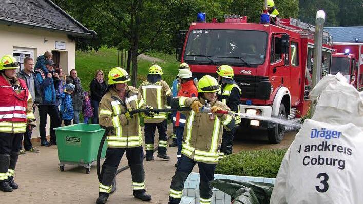 Stellvertretender Kommandant Norbert Wurst verfolgt, wie der Schutzanzug einer Einsatzkraft per Wasserstrahl gereinigt wird. Foto: Klaus Oelzner