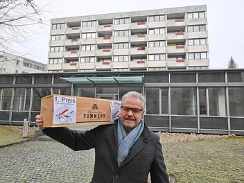 Horst-Peter Müller steht mit einer Kiste Champagner vor dem Herold-Haus, um das es in seinem "Weihnachtsrätsel" geht. Foto: Ronald Rinklef