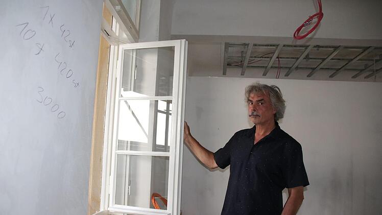 Architekt Christian Teichmann öffnet eines der restaurierten und neu verglasten Kastenfenster. Dahinter ist oben das Lichtband zu erkennen, das die früheren Badekabinen und künftigen Büros verbindet.