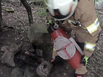 Mit einer Kübelspritze löschte die Zeiler Feuerwehr das Lagerfeuer, das leicht zu einem Waldbrand hätten werden können.  Foto: Christian Licha