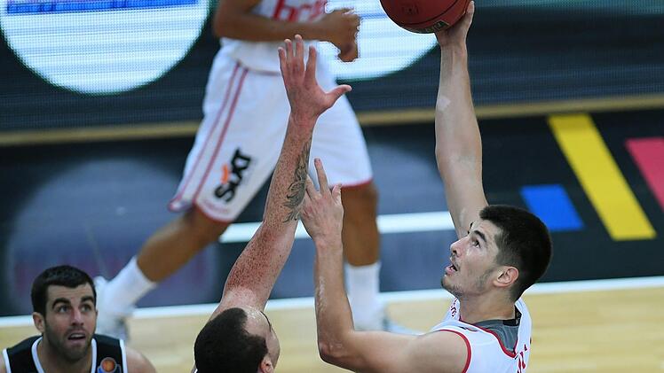 Der Bamberger Luka Mitrovic (r.) ist mit einem Hakenwurf gegen Reggie Upshaw erfolgreich; links beobachtet Jared Jordan die Aktion des Serben. Foto: Markus Ulmer