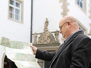 Tourismusreferent Klaus Schebler schaut im Schlosshof auf die Radwanderkarte. Er möchte, dass die Stadt zehn E-Bikes kauft, die Touristen, aber auch Einheimische im Schloss ausleihen können.  Foto: Thomas Malz