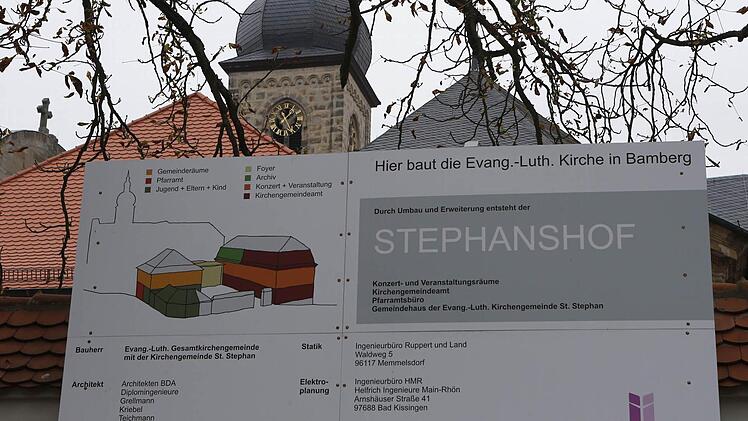 Die Tafel informiert über das Bauvorhaben neben der Stephanskirche (Hintergrund). Foto: Matthias Hoch