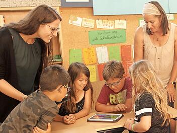 Die kommunale Jugendbeauftragte Eva Pfeil (links) und Klassenlehrerin Kerstin Fischer von der 4b begleiteten die Schüler (von links) Leon, Nele, Luca und Annabell bei ihrer Arbeit am Tablet. Foto: Günther Geiling
