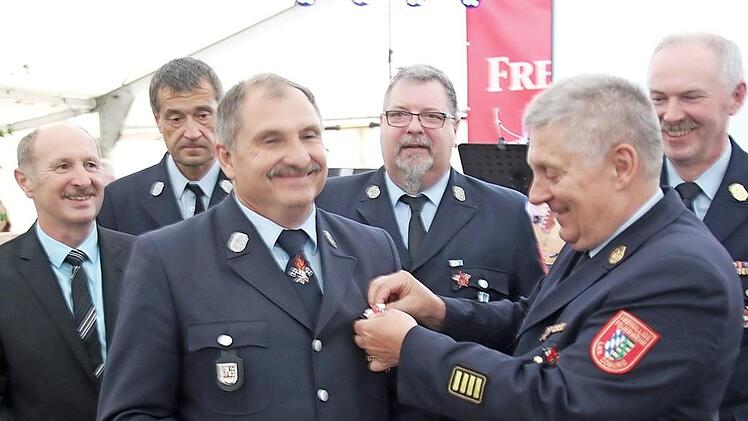 Kreisbrandrat Manfred Lorenz (rechts) zeichnet Alexander Raab aus.