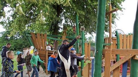 Alle Kinder lud Diakon Joachim Stapf ein, mit ihm gemeinsam den neuen Spielplatz zu segnen - und sie waren mit Feuereifer dabei.  Foto: sw