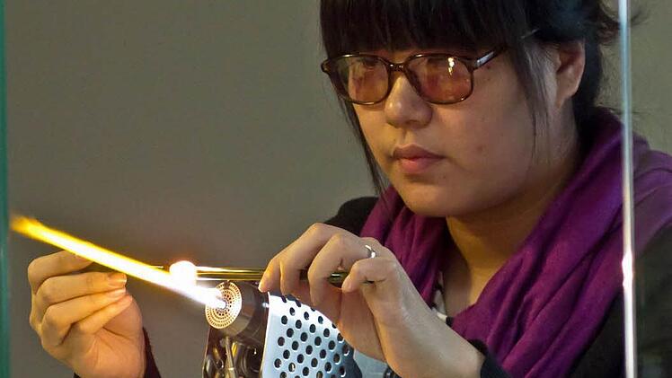 Yi Peng bei der Arbeit im Lampenglasstudio des Glasmuseums Rosenau.Fotos: Jochen Berger