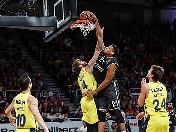 Brose-Center Augustine Rubit schließt gegen Nicolo Melli mit einem Dunking ab. Jan Vesely (r.) von Fenerbahce Istanbul beobachtet die spektakuläre Aktion. Fotos: Daniel Löb