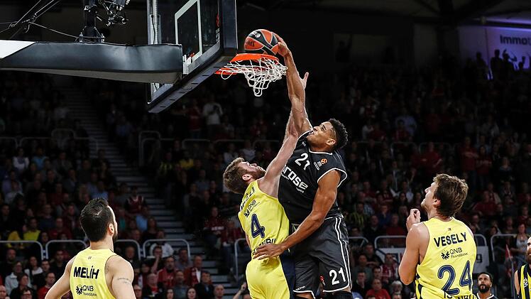 Brose-Center Augustine Rubit schließt gegen Nicolo Melli mit einem Dunking ab. Jan Vesely (r.) von Fenerbahce Istanbul beobachtet die spektakuläre Aktion. Fotos: Daniel Löb