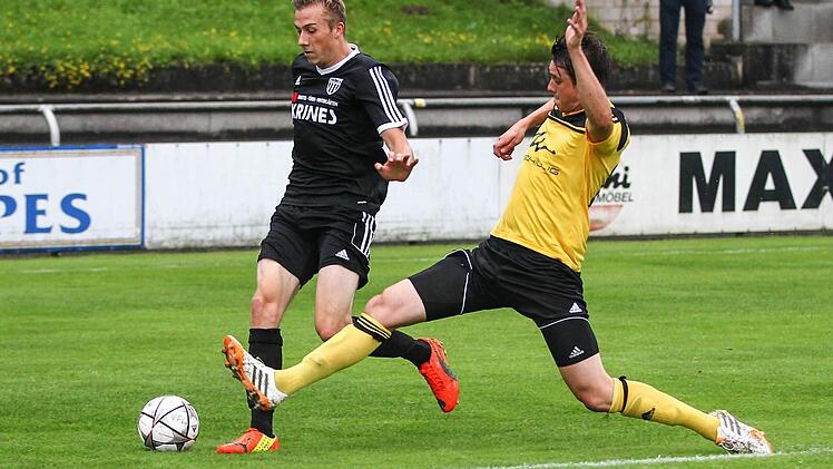Mit langem Fuß versucht Frohnlachs Stefano Göhring (gelb) die Flanke von Marc Fischer zu verhindern.