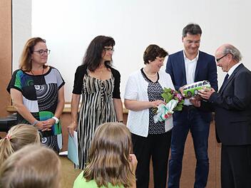 Mit dem Modelll eines VW-Busses verabschieden die Kollegen ihren Schulleiter Ulrich Raab (r.).  Foto: Franz Galster