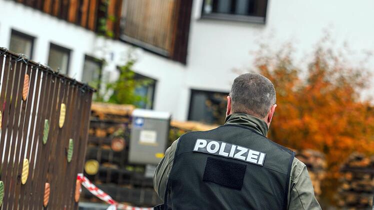 Ein Polizist geht am 19.10.2016 in Georgensgmünd (Bayern) vor einem Haus entlang, in dem ein 49-Jähriger Angehöriger der Reichsbürger-Bewegung am Morgen bei einer Razzia vier Polizisten durch Schüsse zum Teil schwer verletzt hatte. Er hatte laut dem bayerischen Innenminister Hermann 30 Waffen. Foto: Nicolas Armer/dpa
