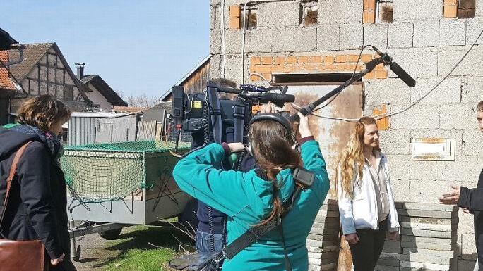 Sie renovieren gerade an allen Ecken und Enden: Monika Grabski und Sebastian Oppel (hinten) erzählen dem Filmteam von der Herausforderung, der sie sich gestellt haben. Vorne rechts steht der Bundorfer Bürgermeister Hubert Endres. Foto: MariaLöffler