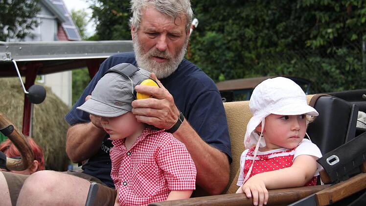 Hans Dünninger schützt die Enkel vor dem Traktorenlärm mit Ohrenschützern.