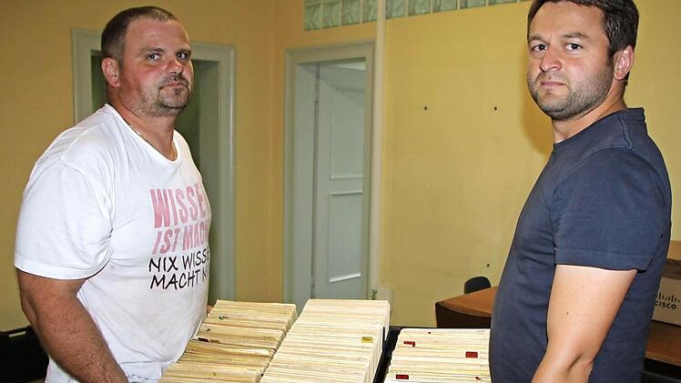 Kistenweise Karteikarten: Matthias Schmitt und Thomas Brand vom Bauhof helfen beim Umzug mit. Foto: Sebastian Vogt