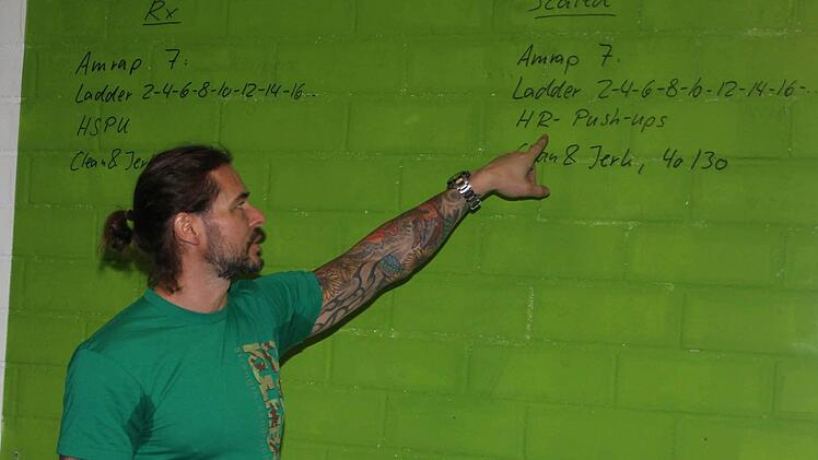 Müller erklärt die Übungen, die die Athleten, die bei der "Cross-Fit-Battle" in Kulmbach mitmachten, absolvieren mussten. Insgesamt gab es zwei Klassen - die RX-Klasse für Fortgeschrittene, die Scaled-Klasse für Anfänger mit leichteren Übungen und geringeren Gewichten. Foto: Sonja Adam