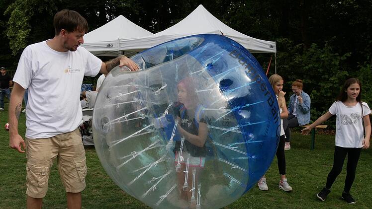 Alex Herr (links) vom Familienzentrum gibt Anweisungen, wie man den Bubble-Ball austrickst, wenn man drinsteckt.     Foto: Manja von Nida