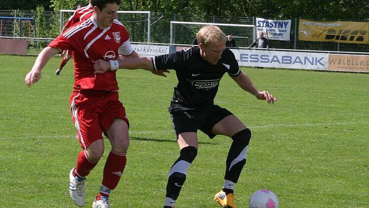 Kampf um den Ball zwischen dem Eberner Heidenreich (rotes Trikot) und Knöffel.