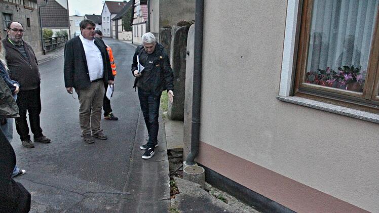 Einige Schadstellen an Gehwegen und neben der Ortsdurchfahrt sind in Gemeinfeld vorhanden, die wie Reinhold Klein (rechts) zeigt, behoben werden sollten. Dritter von rechts, Bürgermeister Hermann Niediek (Mitte) und Gemeinderat Bertram Reuß (links), sind auch dieser Meinung.Helmut Will