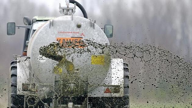 Ein Landwirt bringt Gülle auf einem Feld aus: ein Zankapfel, der viele Gemüter erregt. Foto: Jochen Lübke dpa/lni/Archiv