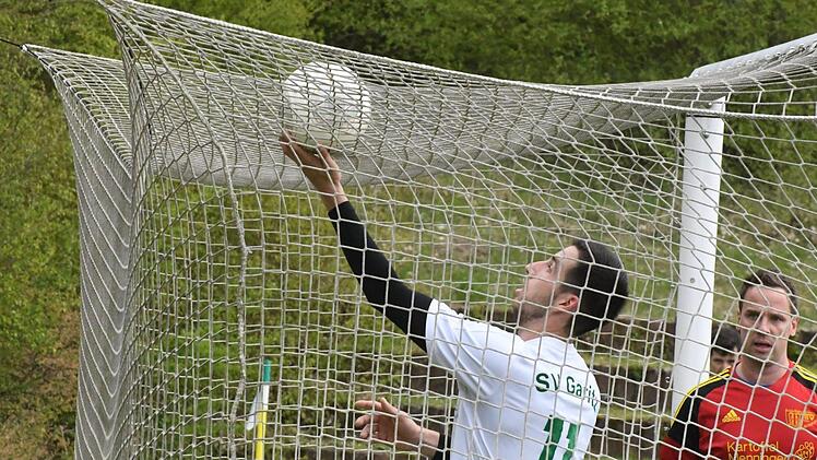 Natürlich hätte der Garitzer Offensivmann Christoph Schießer das Leder lieber aus dem Netz geholt beim 2:2-Remis im Kreisliga-Match gegen die SG Heustreu um Thorsten Dietz (rechts). Foto: Hopf