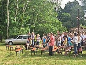 Der traditionelle Gottesdienst unter freiem Himmel wurde auch heuer wieder am "Sonnenstuhl" festlich begangen. Im Hintergrund das große Feldkreuz und der von den St. Georgspfadfindern aufgeschlichtete Holzhaufen für das Johannisfeuer. Foto: Gerhard Wirkner