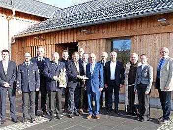 Landrat Klaus Peter Söllner (vorne Bildmitte) überreichte vor dem neuen Steinbacher Dorfgemeinschaftshaus Bürgermeister Franz Uome ein Landkreiswappen, das im Innern des Gebäudes seinen Platz finden wird.  Foto: Klaus-Peter Wulf