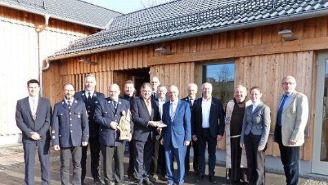Landrat Klaus Peter Söllner (vorne Bildmitte) überreichte vor dem neuen Steinbacher Dorfgemeinschaftshaus Bürgermeister Franz Uome ein Landkreiswappen, das im Innern des Gebäudes seinen Platz finden wird.  Foto: Klaus-Peter Wulf