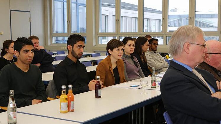 Wie in der Schule: Die jugendlichen Asylbewerber um ihre Lehrerin Bianca Rohrer (braunes Jackett) lauschen der Pressekonferenz ganz genau, in der es um "ihren" berufsorientierten Deutschkurs geht. Foto: Barbara Herbst
