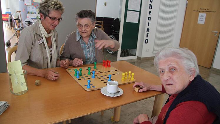 Die neue Pflegedienstleiterin Martina Klemm gesellt sich zu Elfriede Rucker von der Kolping Familie und Grete Zeyher (94), die so gerne Mensch ärgere dich nicht spielt. Das neue Gesetz ist schuld an der drastischen Erhöhung der Entgelte. Foto: Sonja Adam