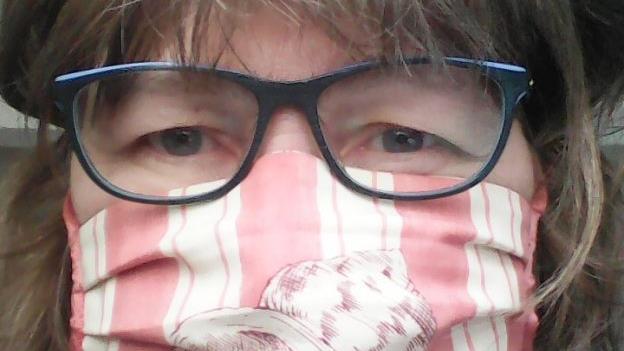 Den äußeren Umständen geschuldet ist auch die Zeitlofser Pfarrerin Barbara Weichert in diesen Tagen mit einem selbstgenähten Gesichtsschutz unterwegs. Selfie: Barbara Weichert