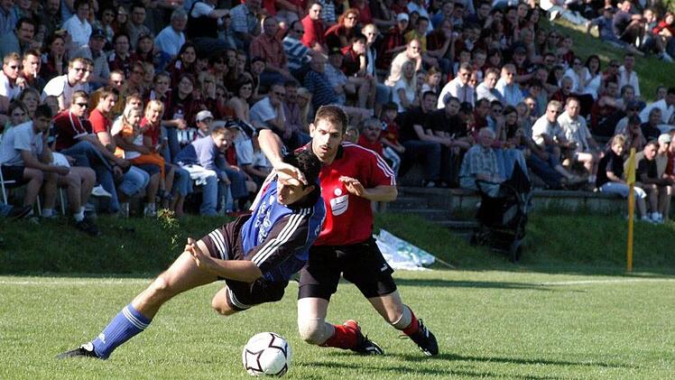 Rassiger Zweikampf: Der Obereschenbacher Sebastian Schübert (links) schirmt den Ball vor dem Schlimpfhofer Uwe Stoeck ab. Foto: Archiv/Hopf