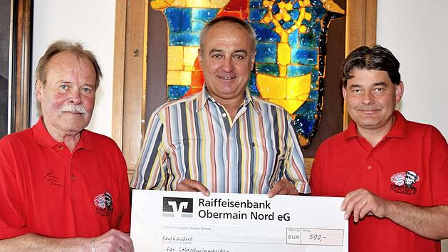 B&uuml;rgermeister Robert H&uuml;mmer nimmt den Scheck in H&ouml;he von 500 Euro vom FC-Bayern-Fanclub Nepomuk entgegen, den Vorstandsmitglied Kurt Larisch und Vorsitzender Marco Jacob (v.&nbsp;l.) f&uuml;r das k&uuml;nftige Lehrschwimmbecken in Altenkunstadt &uuml;berreichten.  Foto: Dieter Radziej