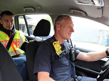Hinter dem Fahrer ist sein Stammplatz: Fabian Korte darf die Beamten der Dienststelle Haßfurt auch auf Einsätze begleiten.  Dann trägt er eine neongelbe Warnweste. Auf dem Bild lenkt Polizeioberkommissar Michael Weidmann das Einsatzfahrzeug. Foto: Katja Müller