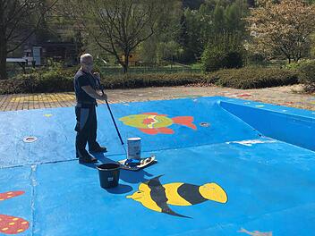 Bademeister Sven Ri&szlig;mann beim Streichen des Kinderbeckens in Egloffstein  Foto: Gemeinde Egloffstein