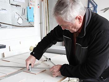 Nicht immer müssen die Fliesen eckig sein. Mit Hilfe eines Zirkels kann Günther Kropf die Kacheln kreisrund schneiden.  Fotos: Franziska Rieger