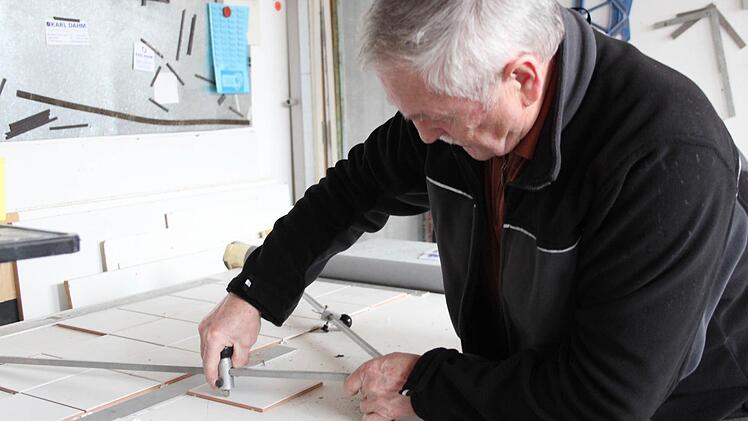 Nicht immer müssen die Fliesen eckig sein. Mit Hilfe eines Zirkels kann Günther Kropf die Kacheln kreisrund schneiden.  Fotos: Franziska Rieger