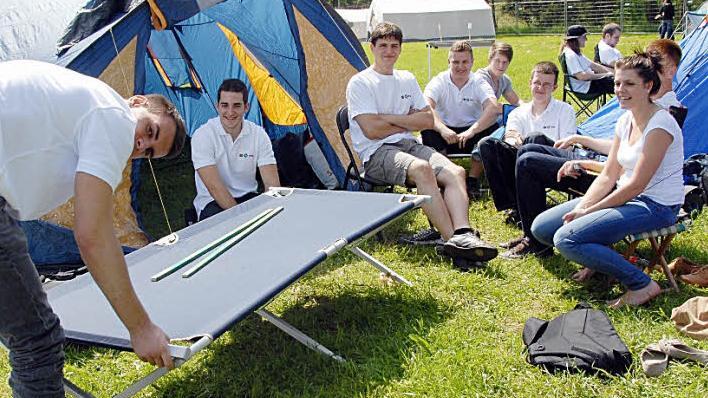 Die Herzogenauracher  Industriemechaniker-Auszubildenden des dritten Lehrjahres   haben nächste Woche Prüfung. Zuvor nehmen sie am Zeltlager  teil.  Michael Baier (l.) baut auf, der Rest schaut amüsiert zu.
