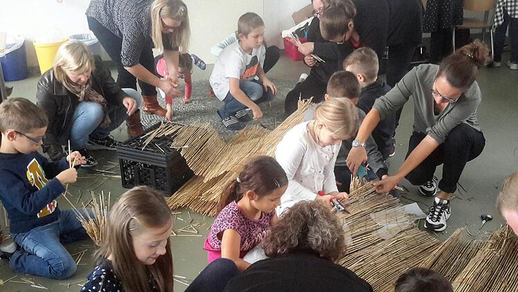 Jede Hand wurde gebraucht, als es beim Projekttag um den Bau von kleinen Insektenhotels ging. In Gemeinschaftsarbeit beteiligten sich Kinder, Eltern und Lehrer am exakten Zuschneiden des Rohmaterials aus gebrauchtem Bambusmatten.Foto: Rolf Pralle