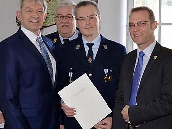 Karl-Heinz Sauer (mit Urkunde) wurde für 40-jährigen aktiven Feuerwehrdienst ausgezeichnet. Unter anderem gratulierte auch Landrat Johann Kalb (links). Foto: p
