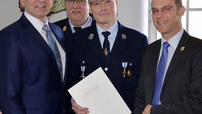 Karl-Heinz Sauer (mit Urkunde) wurde für 40-jährigen aktiven Feuerwehrdienst ausgezeichnet. Unter anderem gratulierte auch Landrat Johann Kalb (links). Foto: p