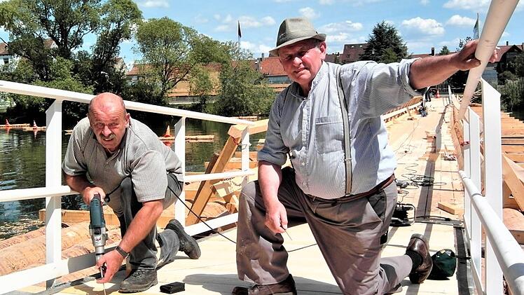 Herbert Doppel (links) beteiligte sich mit großem Einsatz am Bau der Mainfloßbrücke 2011 in Kitzingen. Rechts Otmar Zwingmann (Friesen). Repro: Gerd Fleischmann