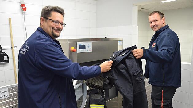 Der Vorsitzende der Kronacher Wehr Stefan Wicklein (links) und Kommandant Christian Büttner freuen sich, dass sie die Einsatzkleidung im neuen Feuerwehrzentrum jetzt auch reinigen und imprägnieren können. Foto: Sandra Hackenberg