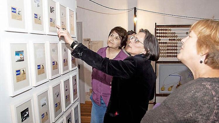 Mia Hochrein (Mitte) erklärt Arbeiten ihrer Kollegin Christiane Schmidt bei der Vernissage der Ausstellung "Island between us" im Heimatspielhaus in Münnerstadt. Foto: Oliver Schikora