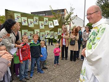 Pfarradministrator Alexander Berberich wird von großen und kleinen Gundelsheimern begrüßt.  Foto: Maria Köppl
