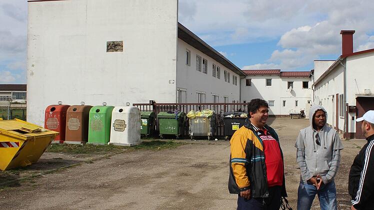 Aus vielen unterschiedlichen Nationen kommen die Asylbewerber, die in der Gemeinschaftsunterkunft in Höchstadt leben. Hier ein Kosovo-Albaner, ein Äthiopier und ein Libanese (von links). Sie sind gespannt, wie der Anbau an dem linken Gebäudeflügel werden soll.  Foto: Archiv/Andreas Dorsch