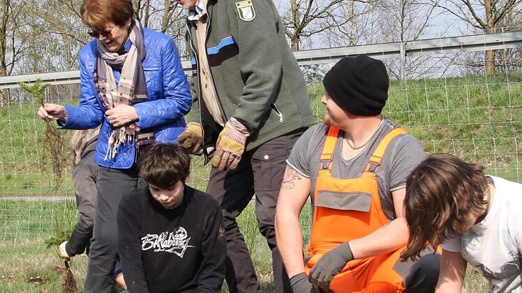 Bürgermeisterin Elke Protzmann (in blau) packt unter der Aufsicht von Förster Frank Wystrach (rechts daneben) mit an.  Rudel