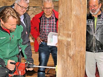 Dieter Britz Georg Brütting (links vorn) bohrte Löcher in einige Balken der Zehntscheune, um aus den Bohrkernen das Alter zu bestimmen. Der Zweite Bürgermeister Wolfgang Rützel (rechts daneben), Marktgemeinderat Winfried Streit und Armin Gernert vom Bauamt der Verwaltungsgemeinschaft Maßbach verfolgten gespannt seine Arbeit.  Foto: Dieter Britz