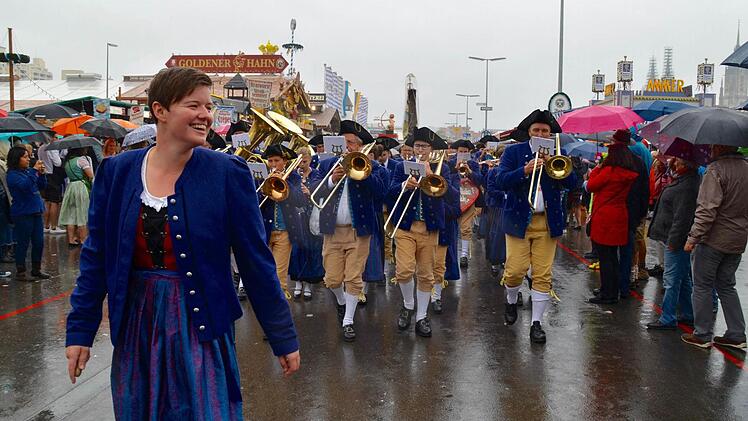 Trotz Regen und Strapazen eines anstrengenden Tages: Die Bläser aus Burkardroth zogen in Marschformation von der Theresienwiese. Vorne freut sich Dirigentin Manuela Möller.  Foto: Kathrin Kupka-Hahn